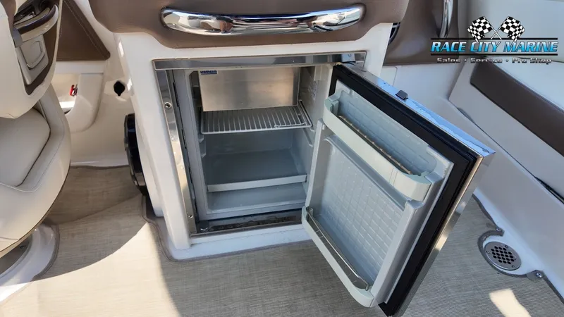 Slide: The Image of An open refrigerator on a 2015 Chaparral 277 SSX boat, featuring beige carpeting. - 43