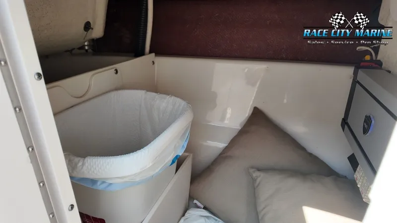 Slide: The Image of The image shows the interior of a 2015 Chaparral 277 SSX with cushions and a trash bin. - 19