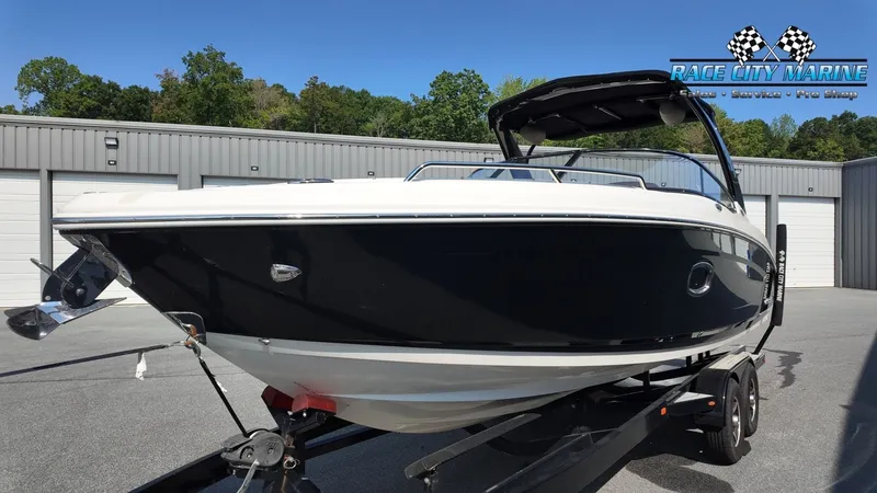 Slide: The Image of A 2015 Chaparral 277 SSX boat on a trailer in front of a gray building. - 6