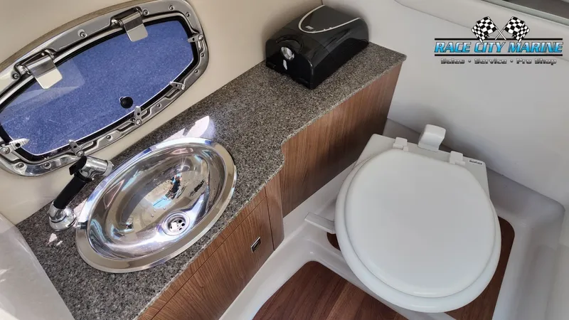 Slide: The Image of The image shows the bathroom of a 2015 Chaparral 277 SSX with a sink and toilet. - 36