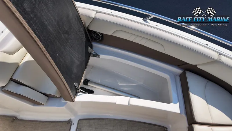 Slide: The Image of The image shows the storage area of a 2015 Chaparral 277 SSX boat with cushioned seating. - 50