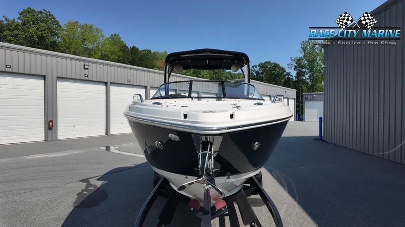 Slide: The Image of A 2015 Chaparral 277 SSX boat on a trailer in front of garages. - 3