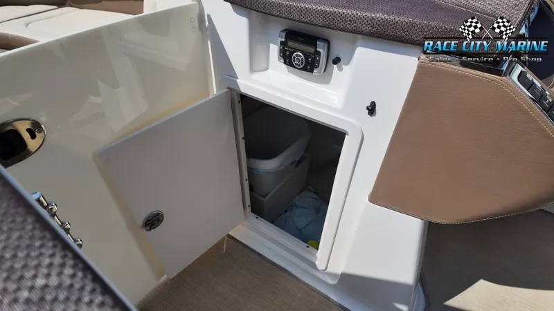Slide: The Image of An open storage compartment on a 2015 Chaparral 277 SSX boat, containing a trash bin. - 20