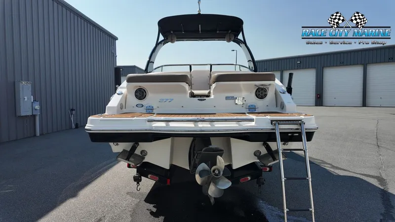 Slide: The Image of The image shows the rear of a 2015 Chaparral 277 SSX boat with a swim platform and ladder. - 4