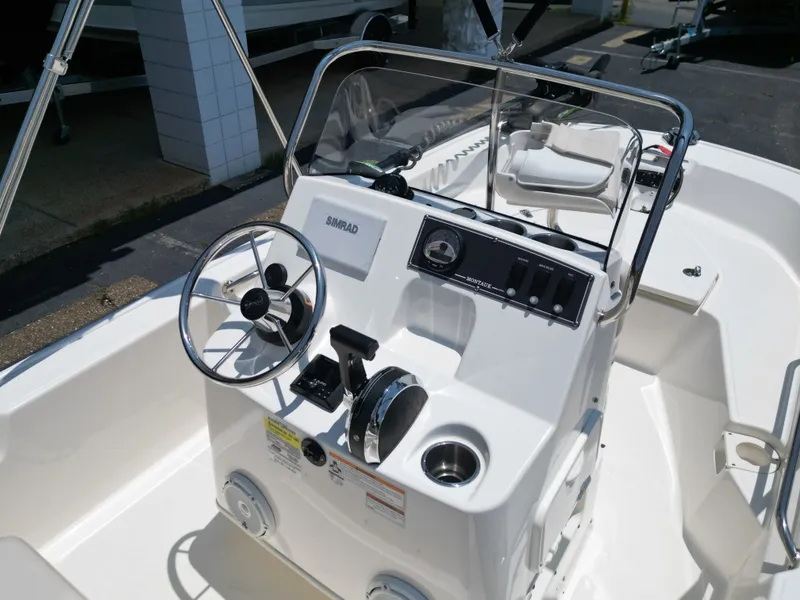 Slide: The Image of The image shows the helm of a 2023 Boston Whaler 150 Montauk with steering wheel and instruments. - 17