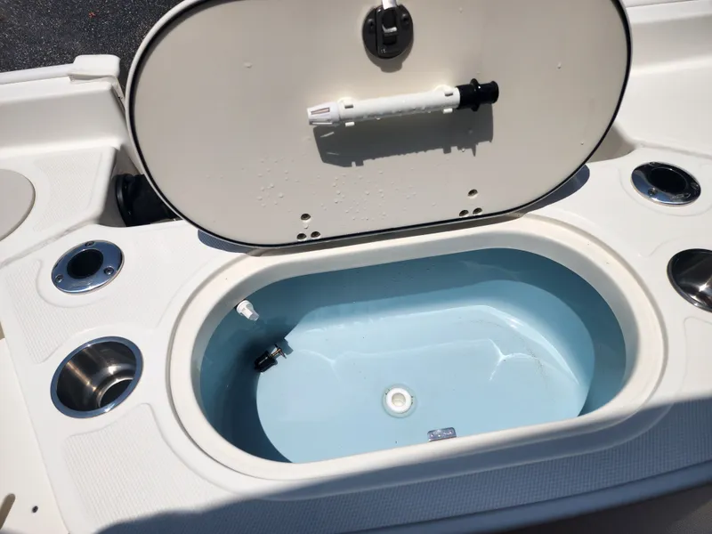 Slide: The Image of An open storage compartment on a Boston Whaler 150 Montauk boat, surrounded by cup holders. - 8