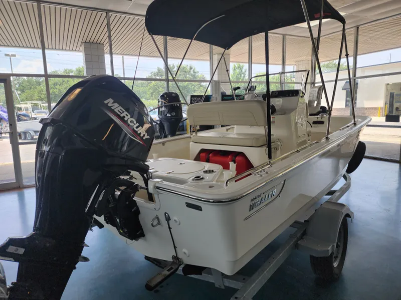 Slide: The Image of A 2023 Boston Whaler 150 Montauk sits on a trailer in a showroom. - 7