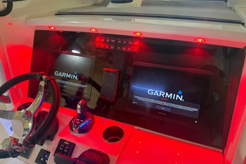 Slide: The Image of 2024 Solace 30HCS boat dashboard with Garmin displays and red ambient lighting. - 11