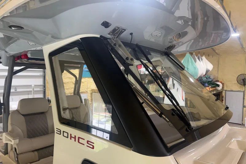 Slide: The Image of 2024 Solace 30HCS boat interior with windshield and seating in a garage setting. - 22