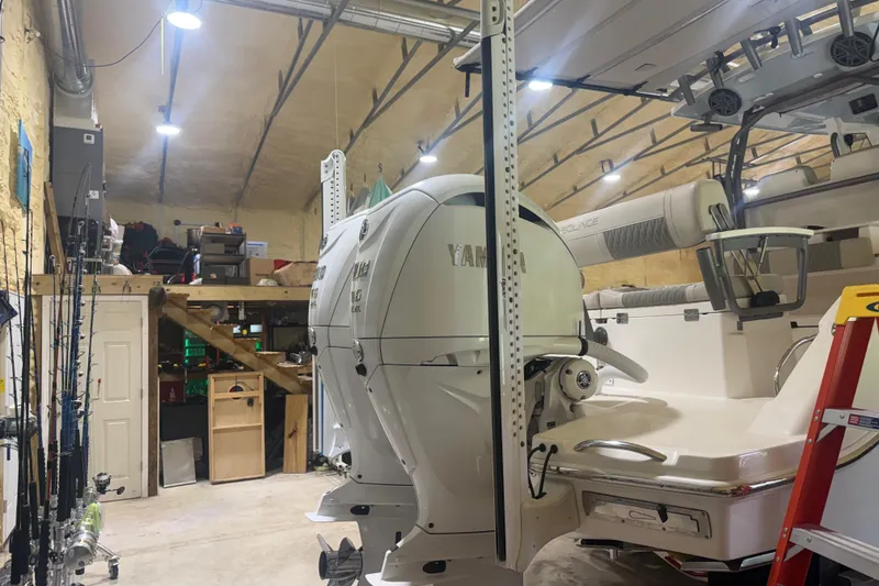 Slide: The Image of 2024 Solace 30HCS boat in a garage with Yamaha engines and fishing gear. - 6
