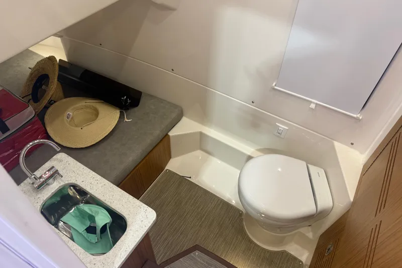 Slide: The Image of Compact bathroom in 2024 Solace 30HCS boat with sink, toilet, and storage area. - 23