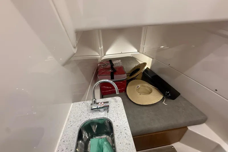 Slide: The Image of 2024 Solace 30HCS cabin interior with sink, hats, and storage items. - 24