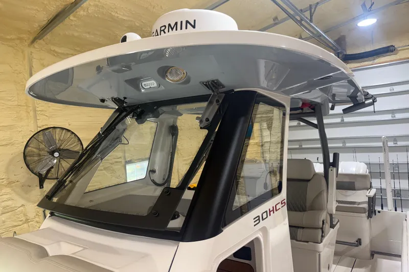 Slide: The Image of 2024 Solace 30HCS boat interior with Garmin equipment in a garage setting. - 21