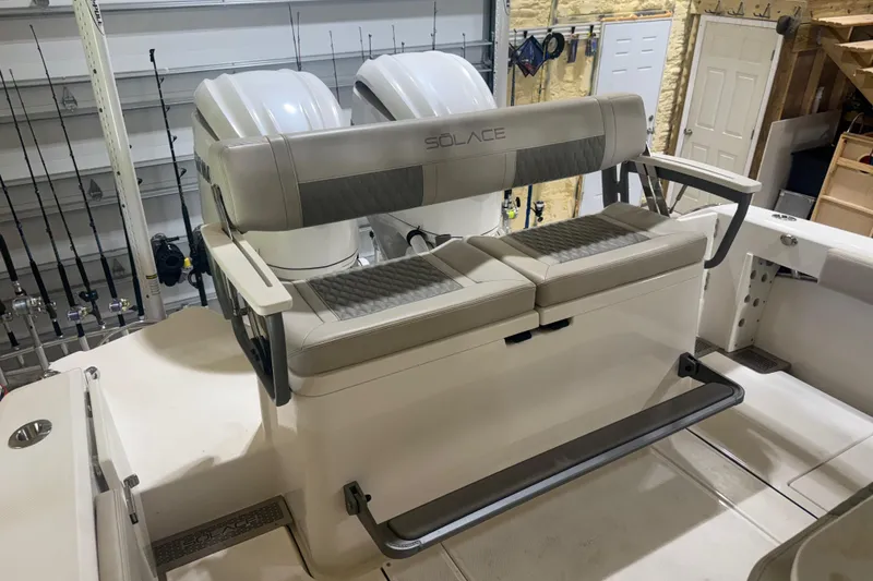 Slide: The Image of 2024 Solace 30HCS boat seating with dual engines in a garage setting. - 20