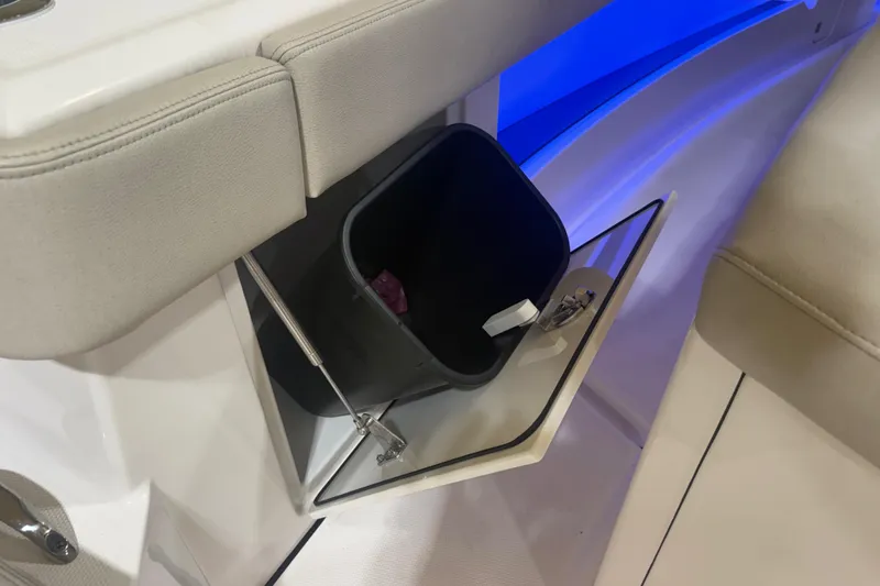Slide: The Image of 2024 Solace 30HCS boat interior with open storage compartment and trash bin. - 40
