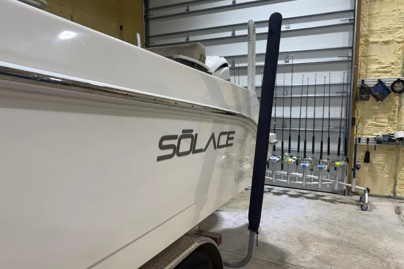 Slide: The Image of 2024 Solace 30HCS boat in garage, fishing rods in background. - 54