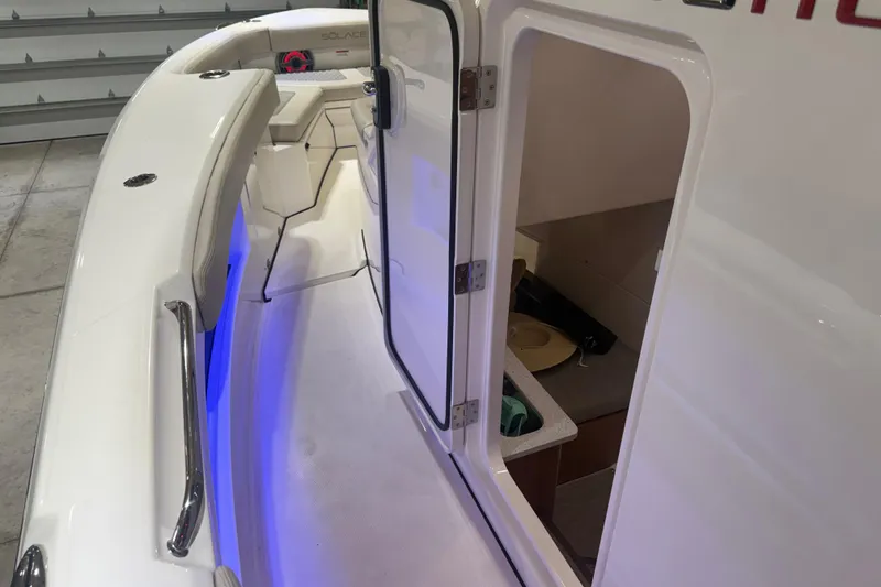 Slide: The Image of 2024 Solace 30HCS boat interior with open cabin door and blue LED lighting. - 16
