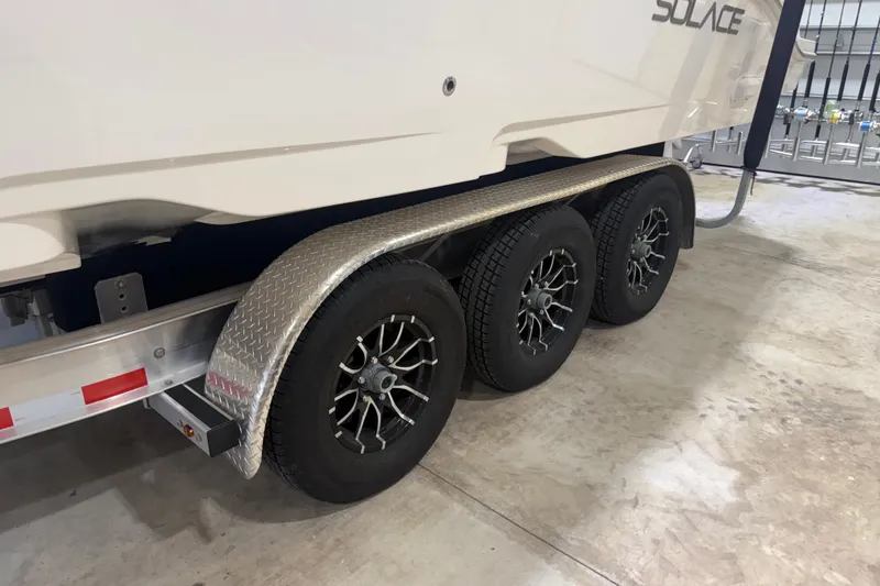 Slide: The Image of 2024 Solace 30HCS trailer with triple axle and stylish black wheels. - 55