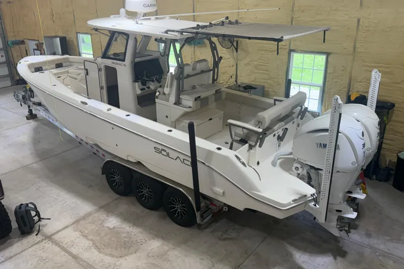 Slide: The Image of 2024 Solace 30HCS boat in garage, featuring dual Yamaha engines and sleek design. - 3