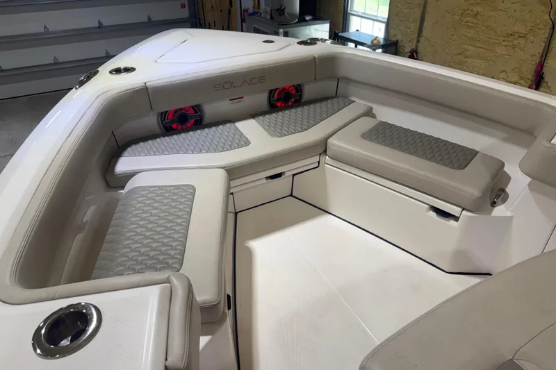 Slide: The Image of 2024 Solace 30HCS boat interior with cushioned seating and cup holders. - 14