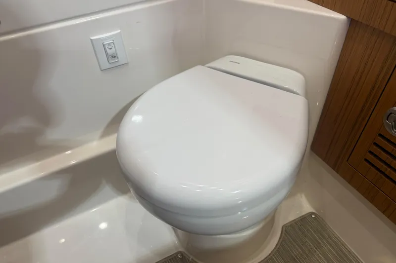 Slide: The Image of 2024 Solace 30HCS bathroom with modern toilet and wooden cabinetry. - 25