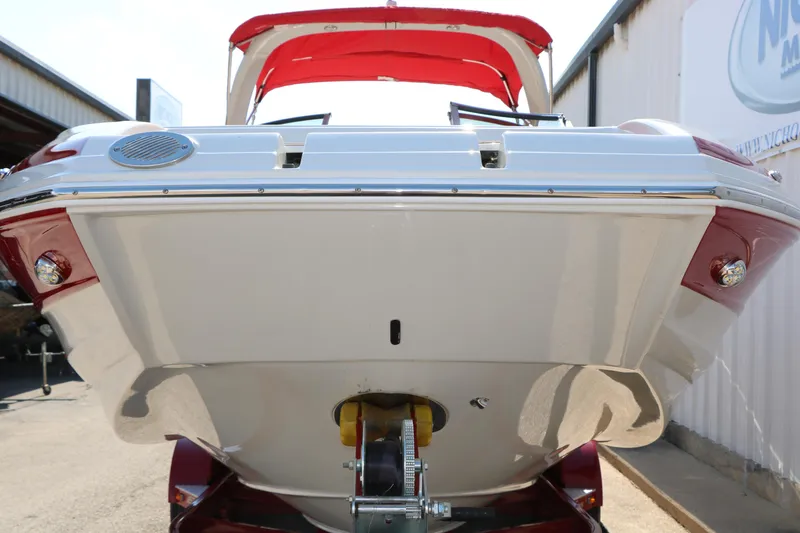 Slide: The Image of 2022 Crownline Eclipse E255 boat with red canopy, viewed from the rear on a trailer. - 16
