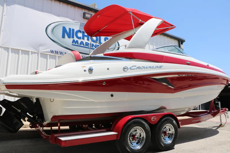 Slide: The Image of 2022 Crownline Eclipse E255 boat with red and white design on trailer. - 2