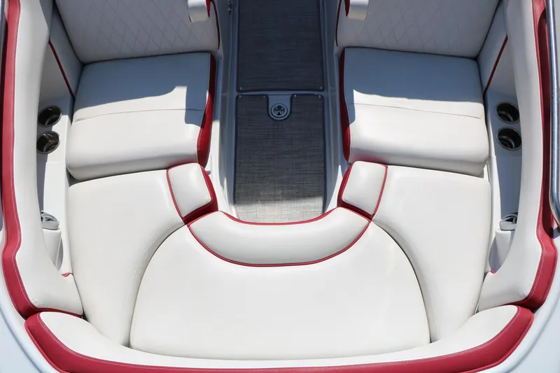 Slide: The Image of Luxurious seating in 2022 Crownline Eclipse E255 boat, featuring white upholstery with red accents. - 32