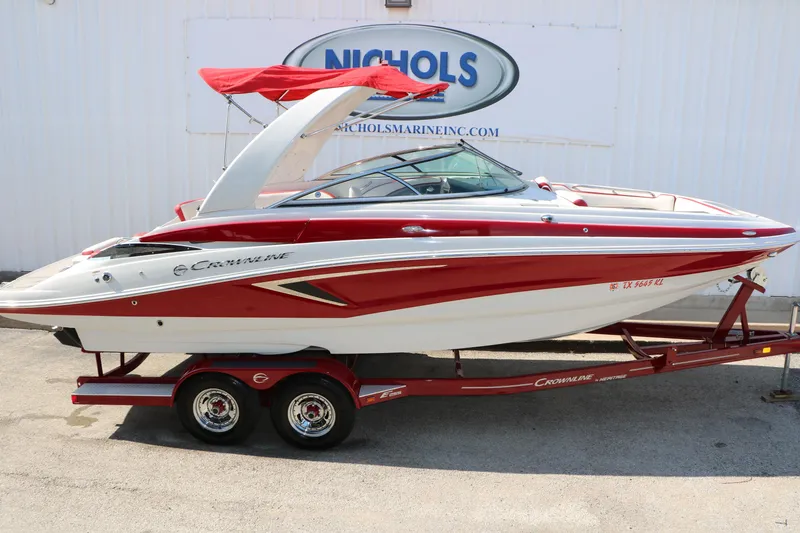 Slide: The Image of 2022 Crownline Eclipse E255 boat with red and white design on a trailer. - 12