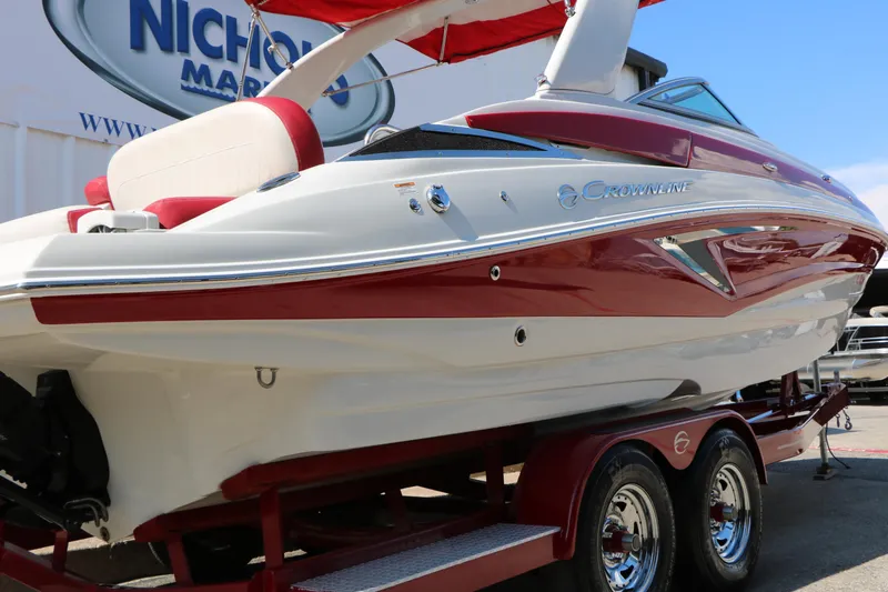 Slide: The Image of 2022 Crownline Eclipse E255 boat with red and white design on a trailer. - 5