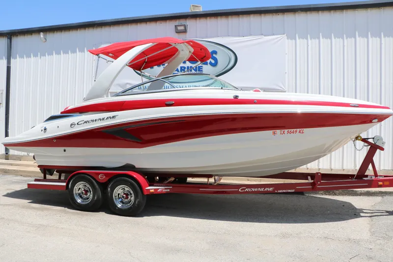 Slide: The Image of 2022 Crownline Eclipse E255 boat with red and white design on a trailer. - 1