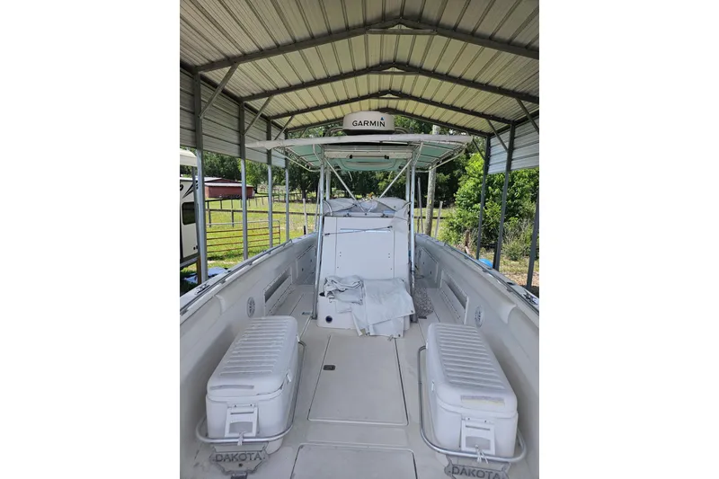 Slide: The Image of 2003 Dakota 36 CC boat under shelter, featuring Garmin equipment and spacious deck. - 33