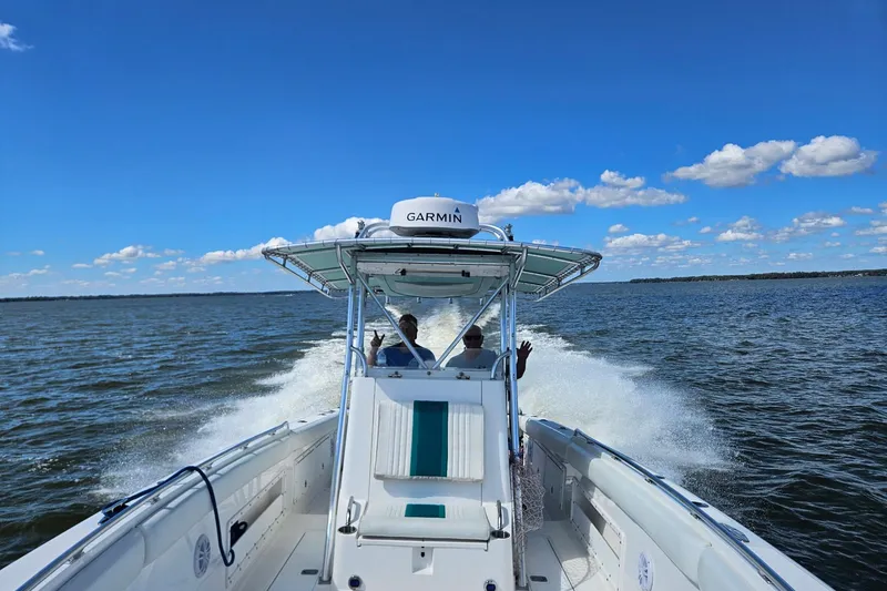 Slide: The Image of 2003 Dakota 36 CC boat cruising on open water under a clear blue sky. - 20