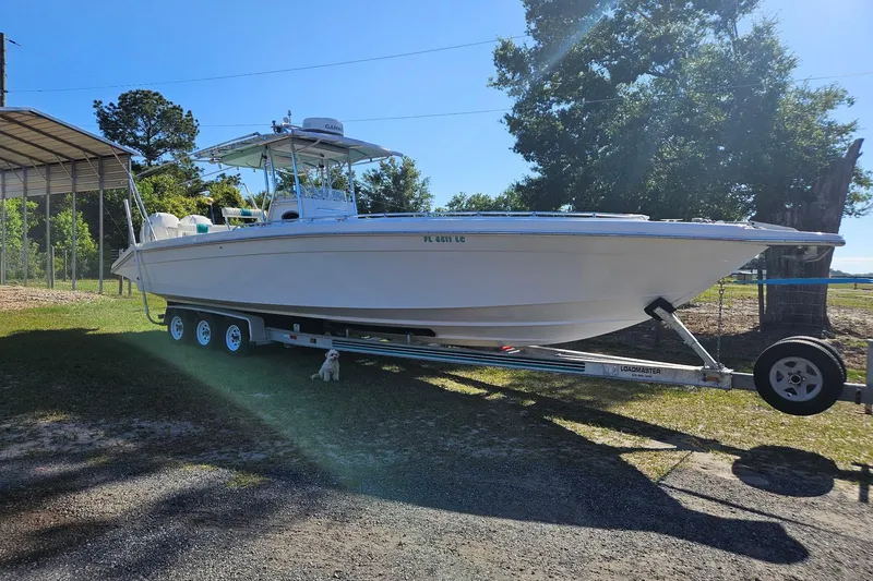 Slide: The Image of 2003 Dakota 36 CC boat on trailer, parked outdoors under sunny skies. - 24