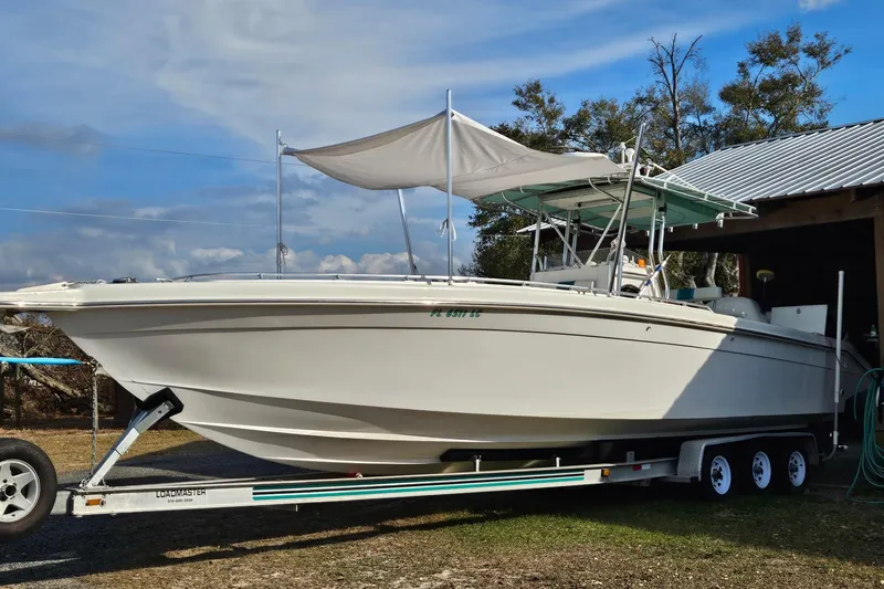 Slide: The Image of 2003 Dakota 36 CC boat on trailer, parked outdoors under a clear sky. - 21