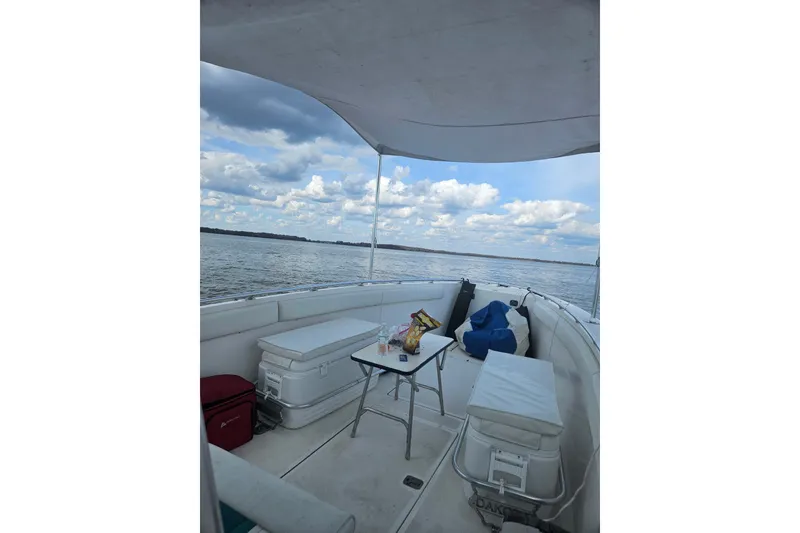 Slide: The Image of 2003 Dakota 36 CC boat interior with seating, table, and open water view. - 23