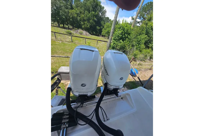 Slide: The Image of Twin Mercury outboard engines on a 2003 Dakota 36 CC boat, surrounded by greenery. - 10