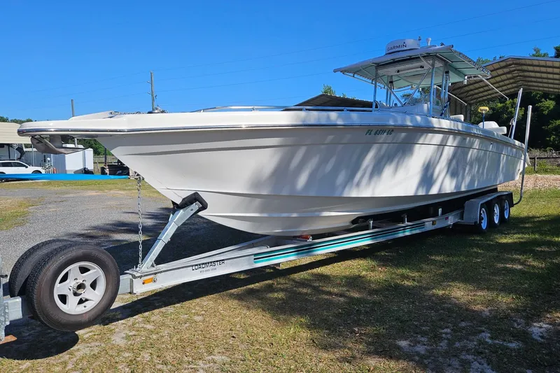 Slide: The Image of 2003 Dakota 36 CC boat on trailer, parked outdoors under clear blue sky. - 7