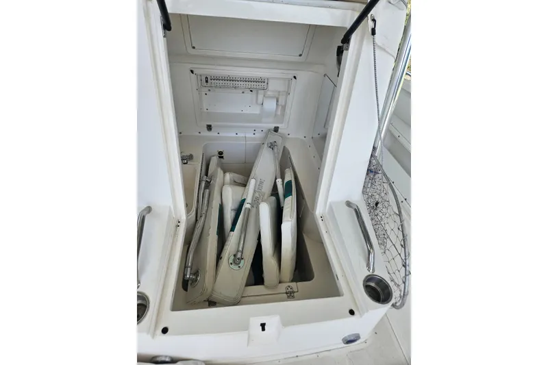 Slide: The Image of Storage compartment on a 2003 Dakota 36 CC boat, containing folded equipment and accessories. - 14