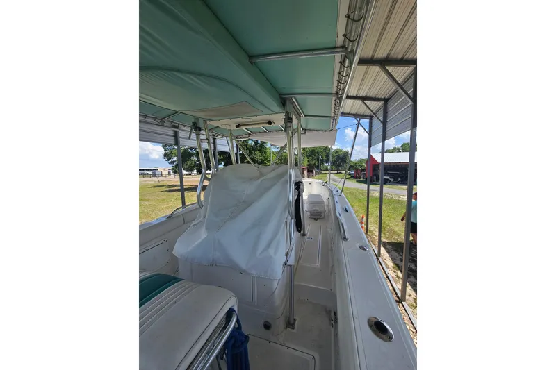 Slide: The Image of 2003 Dakota 36 CC boat under shelter, featuring covered seating and spacious deck. - 35