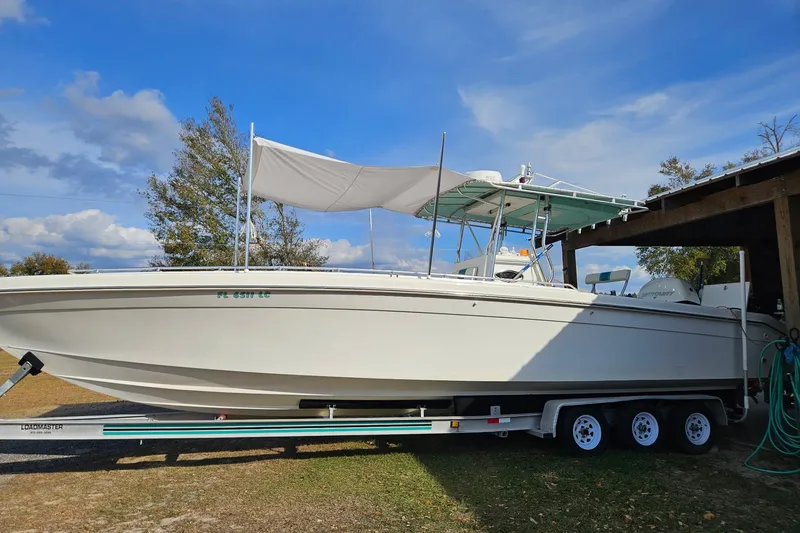 Slide: The Image of 2003 Dakota 36 CC boat on trailer under blue sky, side view. - 5