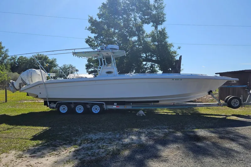 Slide: The Image of 2003 Dakota 36 CC boat on trailer, parked outdoors under clear sky. - 25