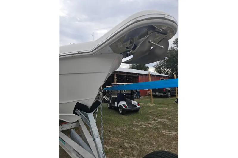 Slide: The Image of 2003 Dakota 36 CC boat on trailer, parked outdoors near a red building. - 18
