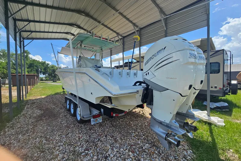 Slide: The Image of 2003 Dakota 36 CC boat with twin Mercury engines under a metal canopy. - 11
