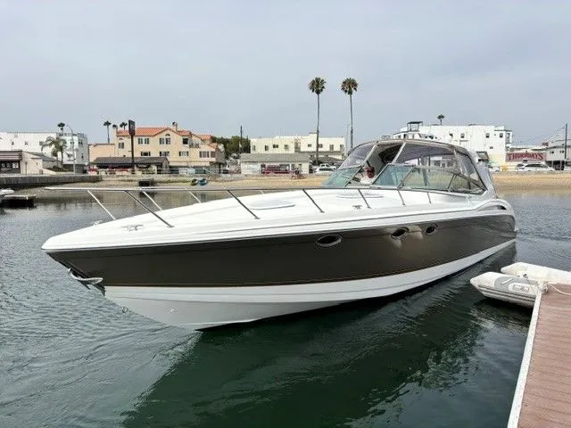 Slide: The Image of A 2003 Formula 400 Super Sport docked in the water. Buildings and palm trees in the background. - 3
