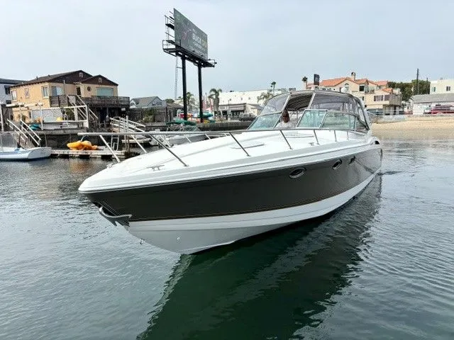 Slide: The Image of A 2003 Formula 400 Super Sport glides on calm water, surrounded by buildings and a billboard. - 5