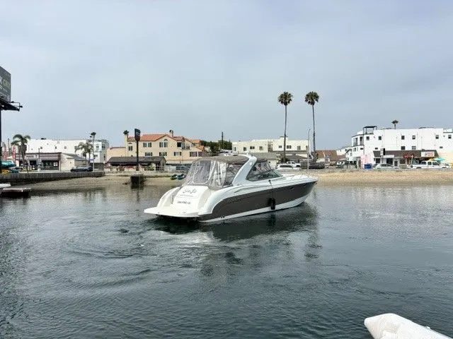 Slide: The Image of A 2003 Formula 400 Super Sport on calm water with an urban backdrop. - 16