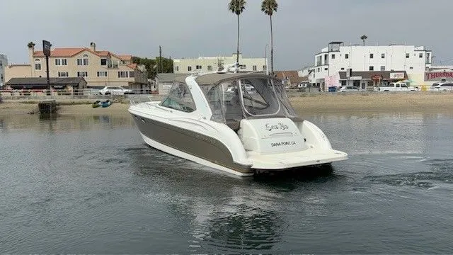 Slide: The Image of A 2003 Formula 400 Super Sport cruising on calm water with an urban backdrop. - 17