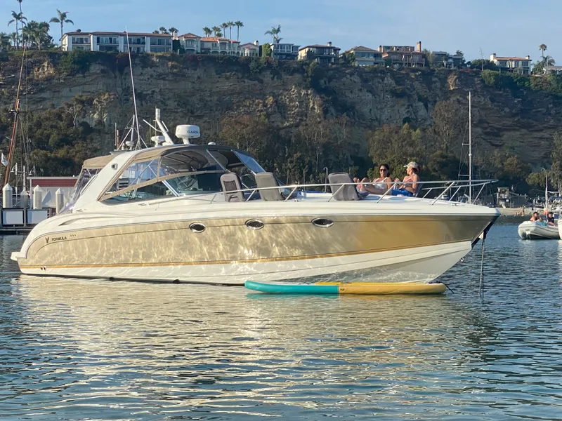 The Image of A luxury motor yacht anchored in a calm harbor, surrounded by scenic cliffs. - 1