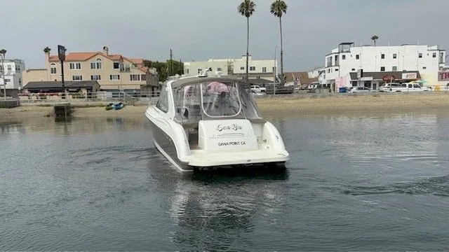 Slide: The Image of A white motor yacht navigates a calm harbor. Buildings and palm trees are visible in the background. - 19